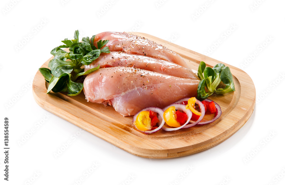 Raw chicken breasts on cutting board 