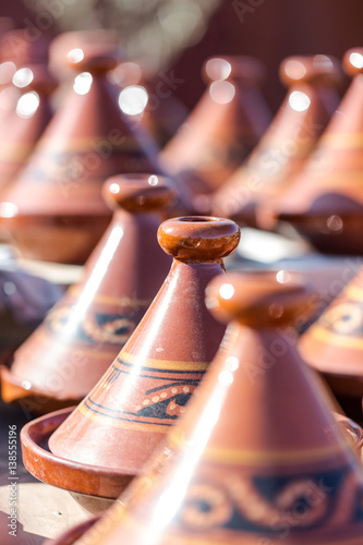 Handmade brown clay tajins for food steaming arranged in rows ready for sell photo