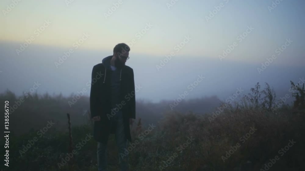 The young guy on the hill in the fog shouting and swearing The young guy on the hill in the fog shouting and swearing