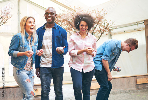 Friends laughing while playing petanque