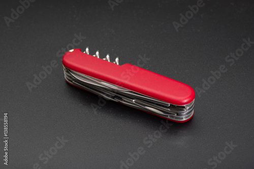 Red multitool knife on black background