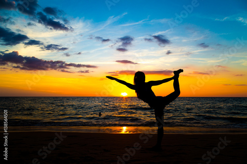 Silhouette sport woman stand yoga on the sea beach
