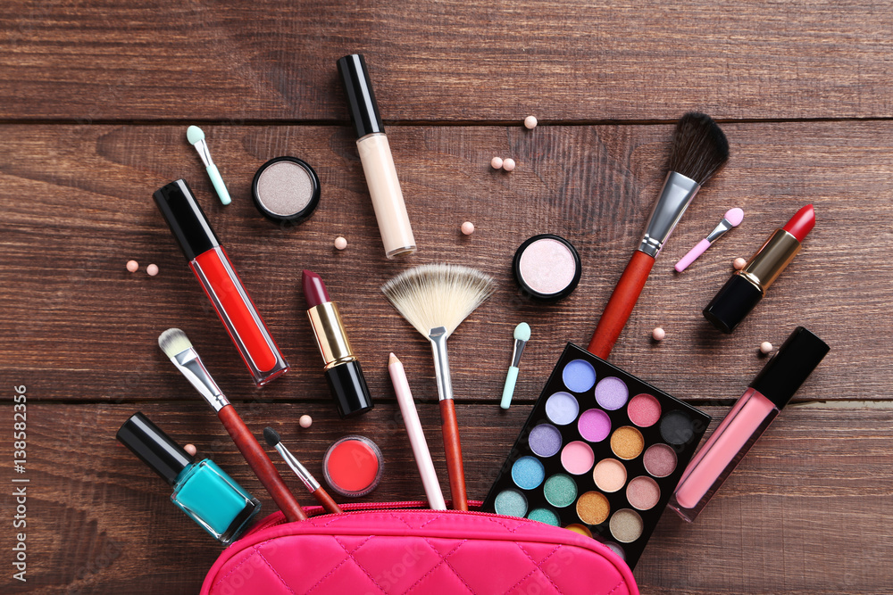 Different makeup cosmetics on brown wooden table Different makeup cosmetics on brown wooden table
