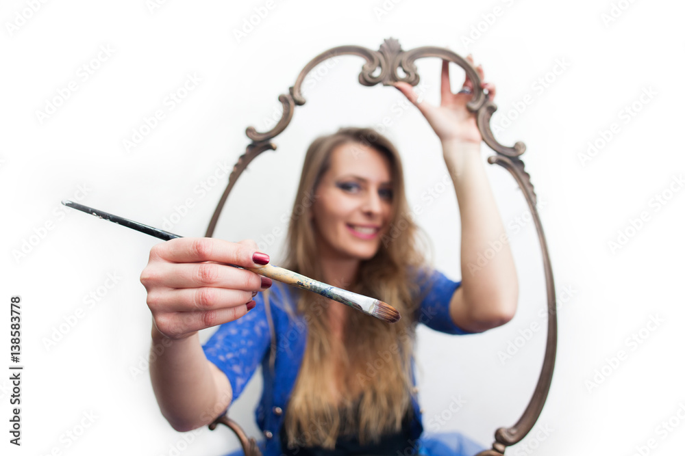 young woman holding paintbrush and reaching out from picture frame young woman holding paintbrush and reaching out from picture frame