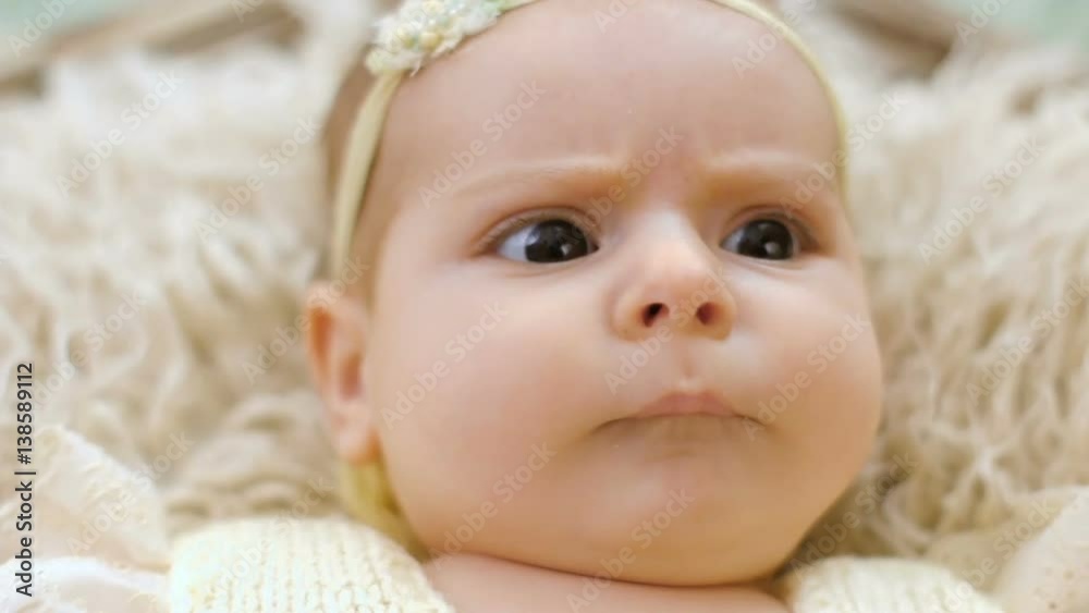 baby girl lies in basket with pink fur