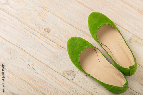 Green women's shoes (ballerinas) on wooden background.