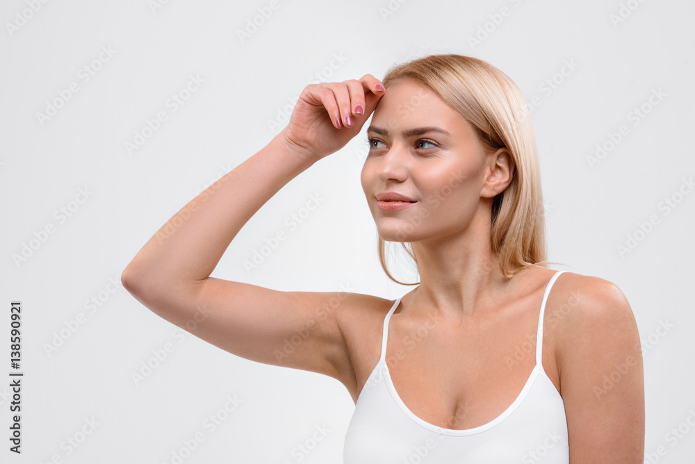 Flirty blond girl standing with pretty smile Flirty blond girl standing with pretty smile