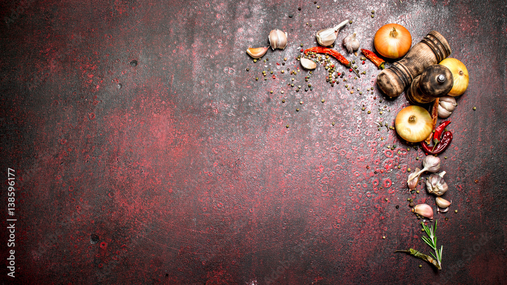 Naklejka premium Fresh spices. A variety of aromatic spices with chili peppers and onions. On rustic background.