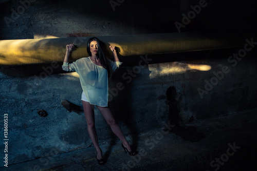 Beautiful alone girl and abandoned sewerage underground with ray of sunshine.