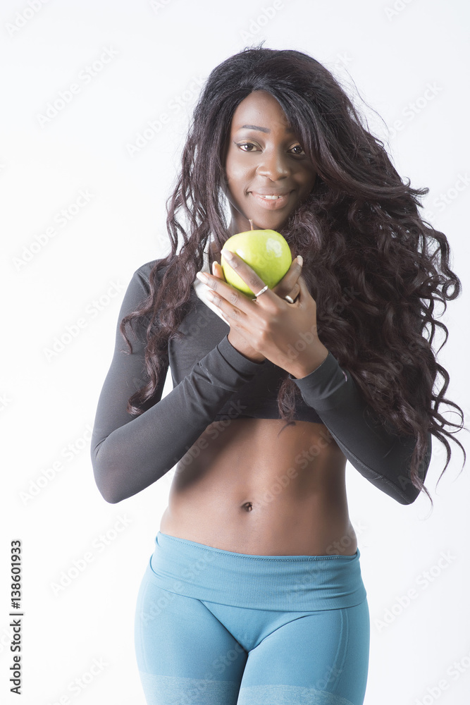 Foto de Beautiful African American Black fitness Model showing her tight  six pack abs while holding a green apple do Stock