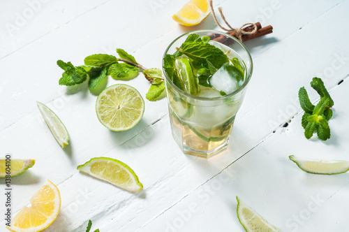 Mojito cocktail with lime and mint in highball glass on a wood white background