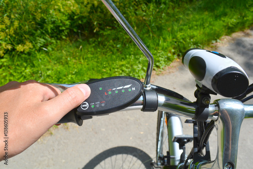Turning on electric bike, E-bike or bicycle. Pressing a button on control board or controller to choose speed and power level. Unfiltered, with natural lighting