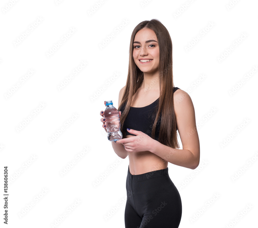 Positive female fitness model after workout holding a bottle of pure water over white background. Positive female fitness model after workout holding a bottle of pure water over white background.