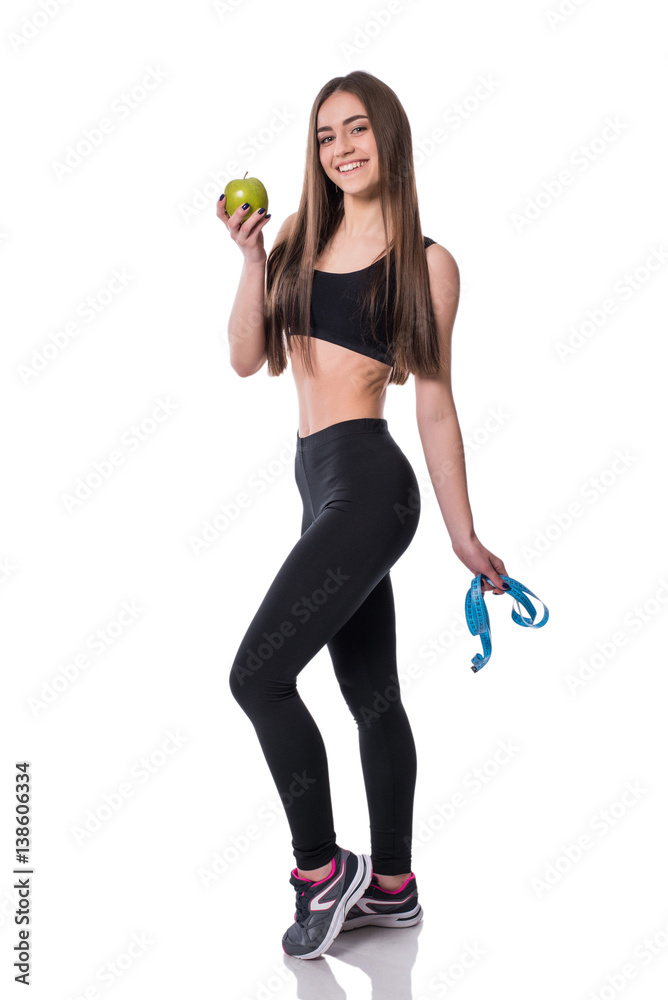 Slim and healthy young woman holding measure tape and apple isolated on white background. Weight loss and diet concept. Slim and healthy young woman holding measure tape and apple isolated on white background. Weight loss and diet concept.