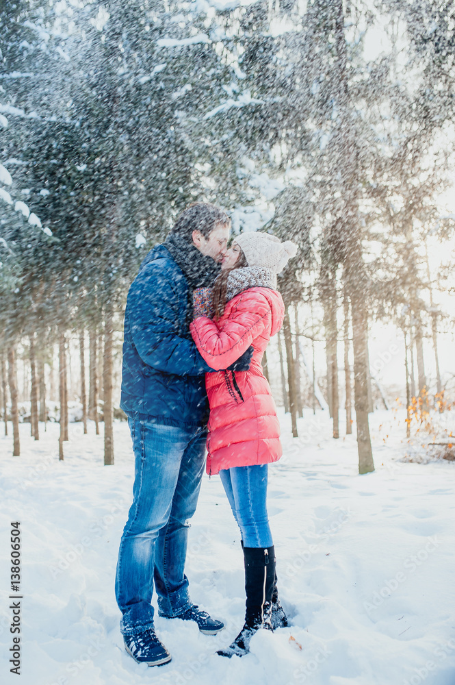 Young couple having fun in the winter forest