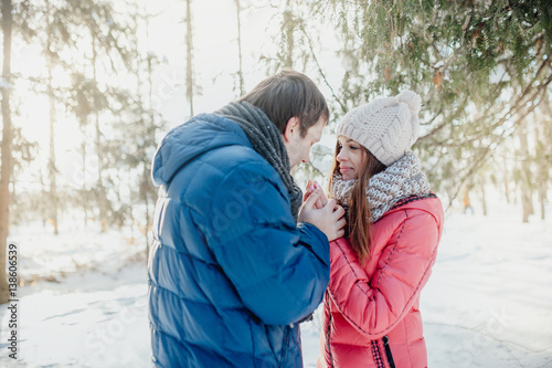 Man with a woman walking in the winter snow park