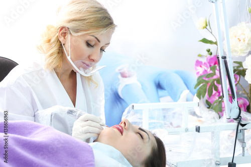 Specialist making permanent makeup in cosmetology salon
