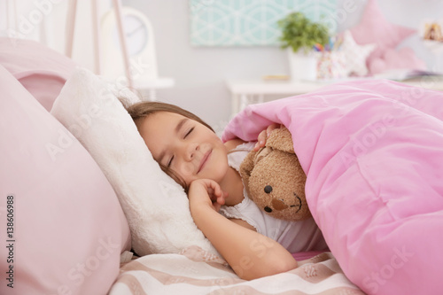 Cute little girl sleeping in bed at home