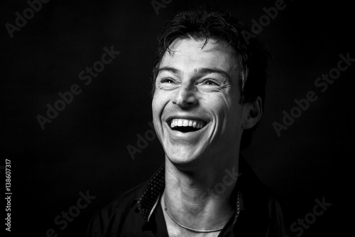 Close up portrait of hard laughing  man. Isolated on black background . Monochrome picture