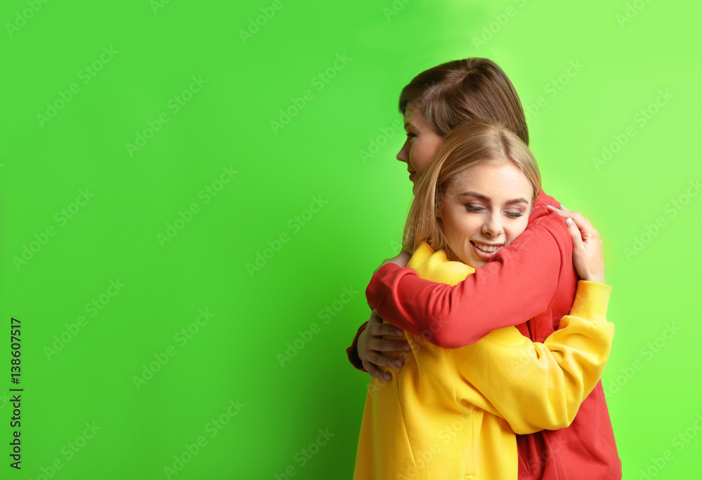 Young lesbian couple on color background Young lesbian couple on color background