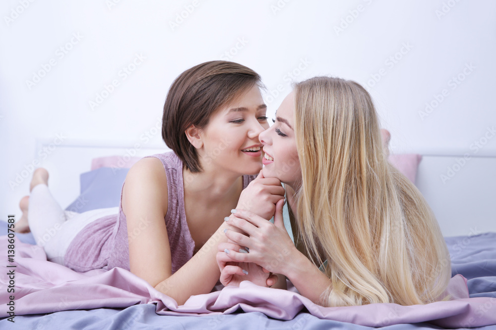 Young lesbian couple lying on bed at home Young lesbian couple lying on bed at home