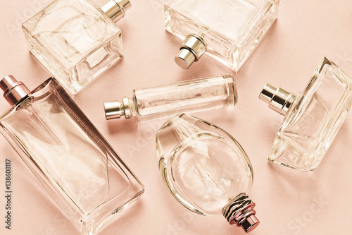 Розовый нежный весенний фон с стеклянными флаконами духов 