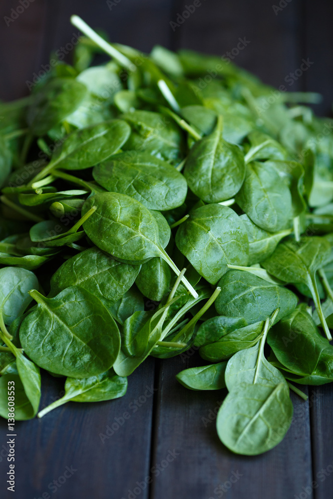 Fresh green spinach on the dark wood background Fresh green spinach on the dark wood background