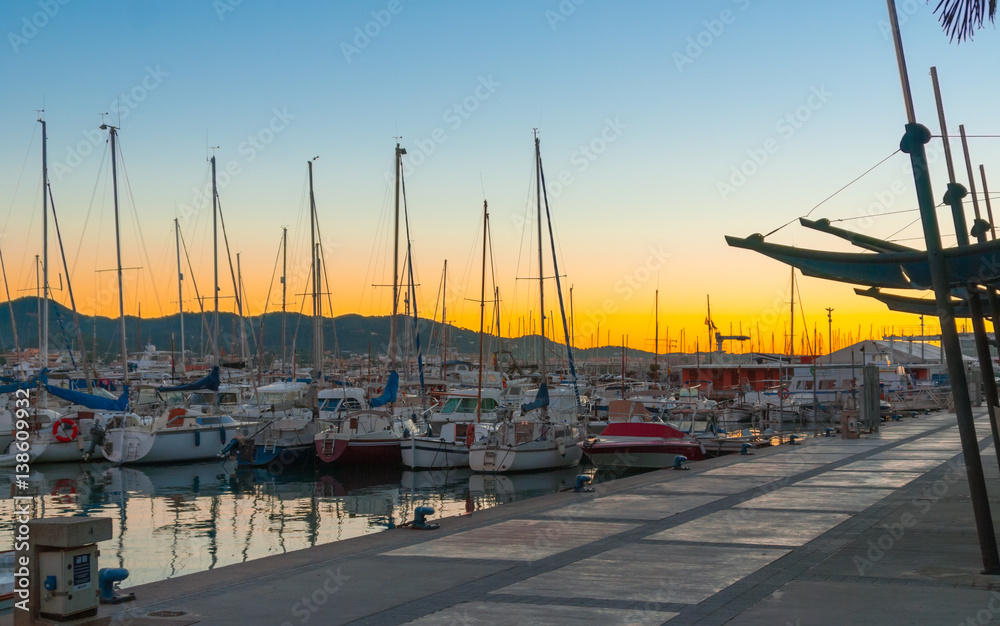 Magnificent sunset color in marina harbor.  End of a warm sunny day in Ibiza, St Antoni de Portmany, Spain. 