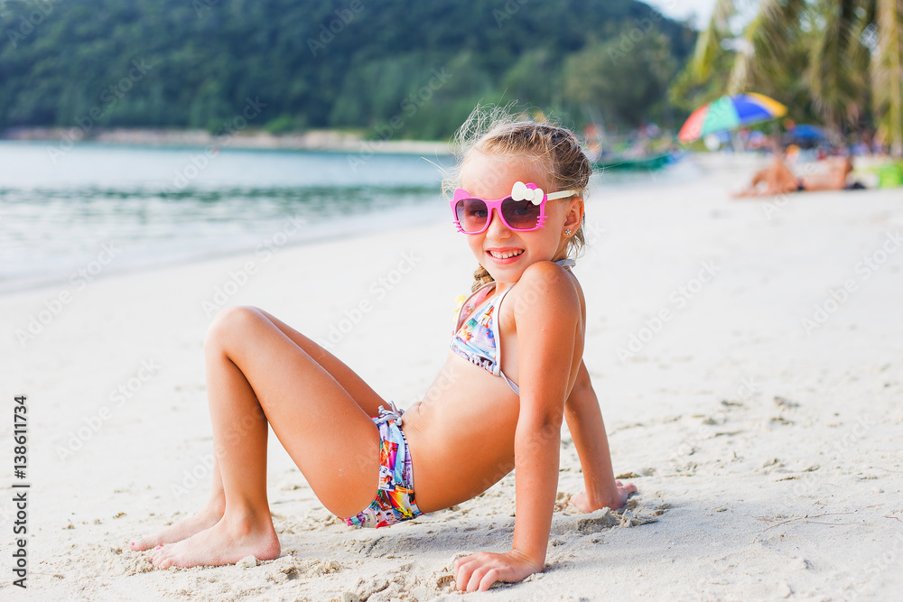 cute little girl in sunglasses and a swimsuit on the beach in paradise by  the sea. Travel and Vacation. Freedom Concept. thailand Stock Photo | Adobe  Stock