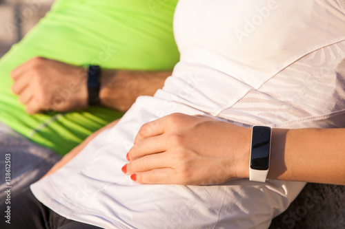 Two people using smart sport watch at workout.