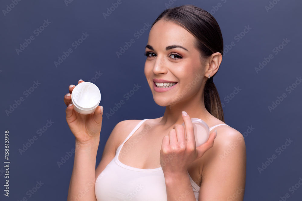 beauty, people, skincare and cosmetics concept - woman with moisturizing cream on hand and facial. beauty, people, skincare and cosmetics concept - woman with moisturizing cream on hand and facial.