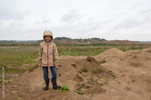 girl walking at sand quarry on rainy day