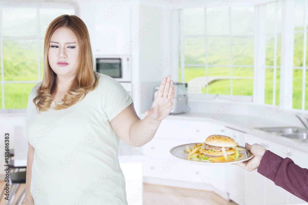 Fat woman is rejecting unhealthy food