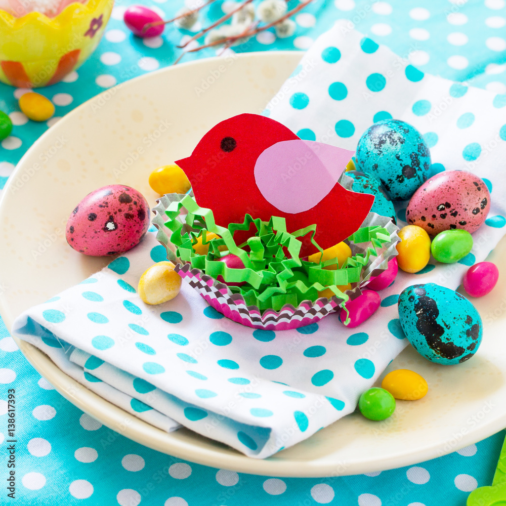 Easter decoration children's table. Decorating Easter table nest with baby bird paper and candy, chicken and eggs.
