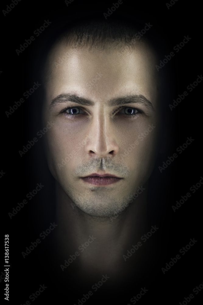 Contrasting male portrait on black background. Light and shadow on the man's face. Stylish, brutal man, art photo. Silhouette face serious macho, expressive eyes Contrasting male portrait on black background. Light and shadow on the man's face. Stylish, brutal man, art photo. Silhouette face serious macho, expressive eyes