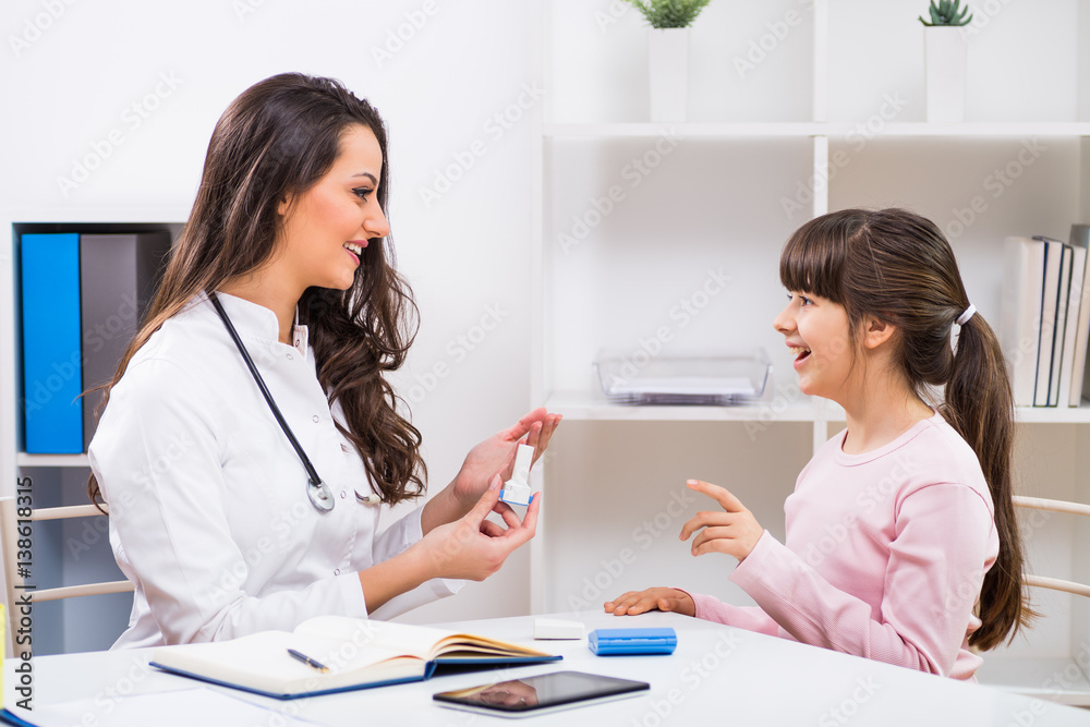Female doctor showing inhaler to a child at the medical office. Female doctor showing inhaler to a child at the medical office.