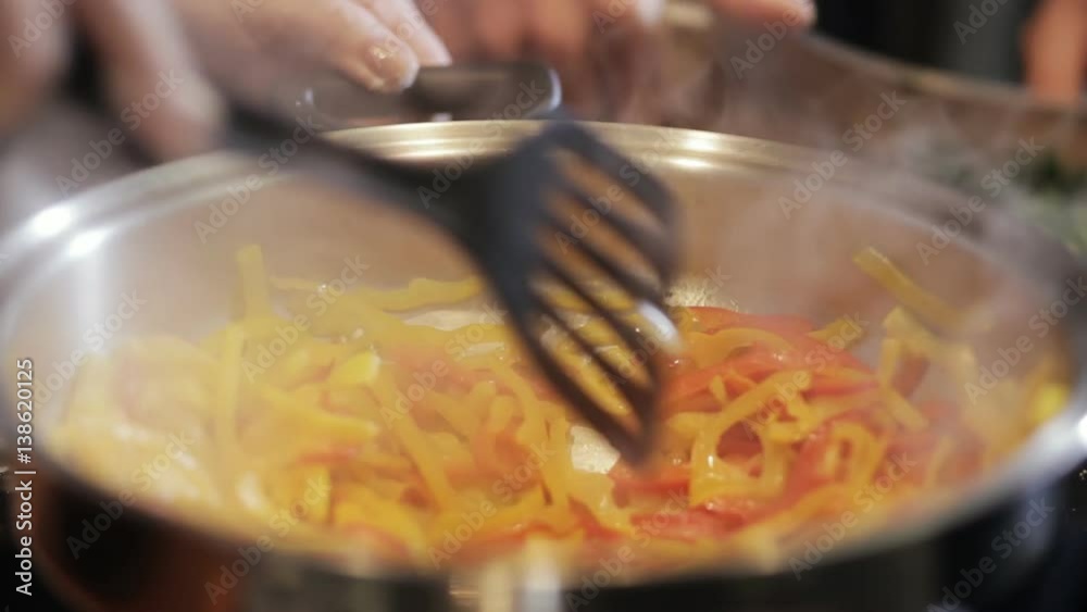 Close-up of chef hands roasting peppers in restaurant kitchen Close-up of chef hands roasting peppers in restaurant kitchen