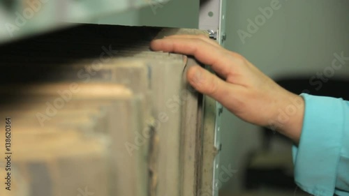 chooses a book in the library