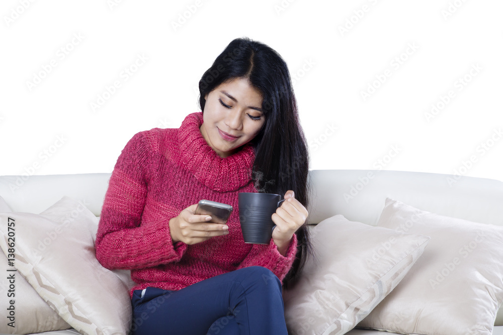 Woman reading messages on a smartphone on studio Woman reading messages on a smartphone on studio