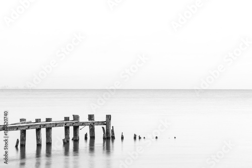 Seascape tranquil background with room for text, rustic pier posts in lower left of water