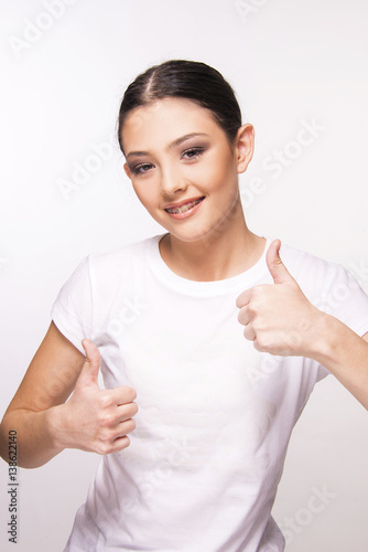 teen girl with brace smiling on white