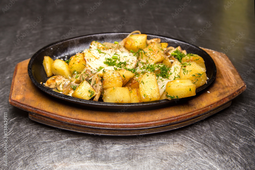 fried potatoes with meat in a frying pan