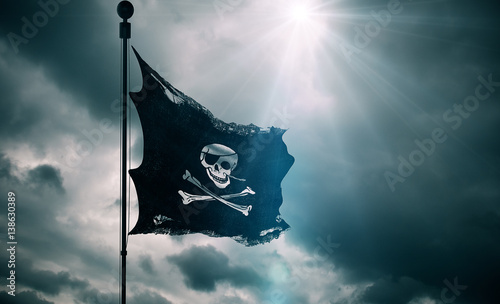 ripped tear grunge old fabric texture of the pirate skull flag waving in wind, calico jack pirate symbol at cloudy sky with sun rays light, dark mystery style, hacker and robber photo