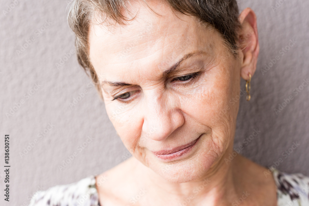 Closeup of older woman with short hair against textured background (selective focus) Closeup of older woman with short hair against textured background (selective focus)