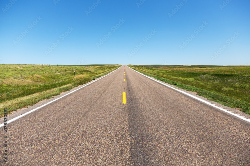 A road cutting through northern Nebraska on a summer day.