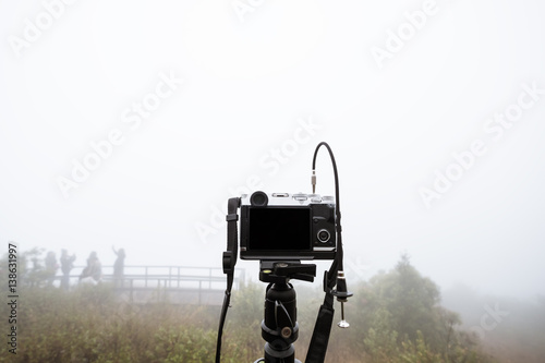 Digital camera on camera tripod, with foggy environment in winter