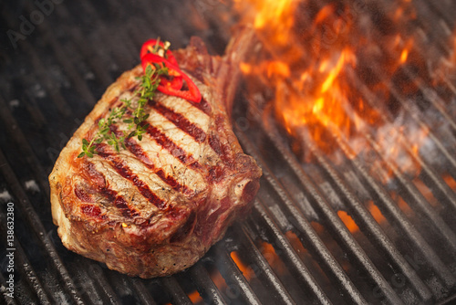 food meat - beef steak on bbq barbecue grill with flame