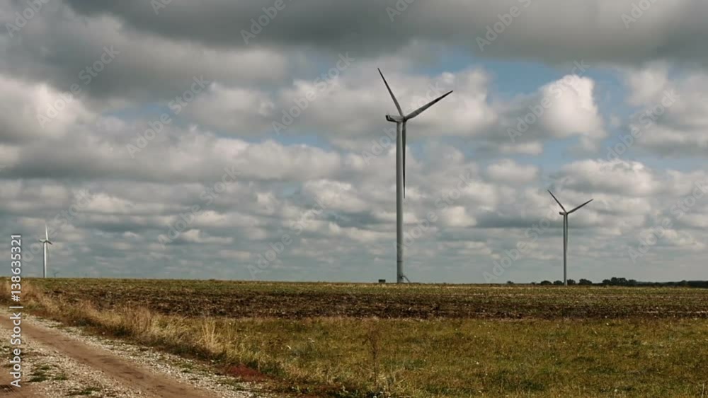 Wind turbines over stormy cloudy sky using renewable energy to generate electrical power. Renewable energy is most environmental way of power generation. Wind turbines over stormy cloudy sky using renewable energy to generate electrical power. Renewable energy is most environmental way of power generation.