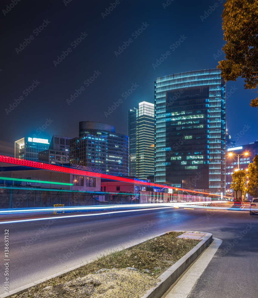 light trails on city street with cityscape at night in China. light trails on city street with cityscape at night in China.