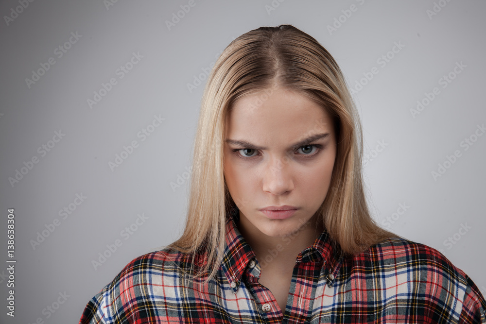 Portrait of a angry young beautiful hipster blonde teenage, Isolated on white background Portrait of a angry young beautiful hipster blonde teenage, Isolated on white background
